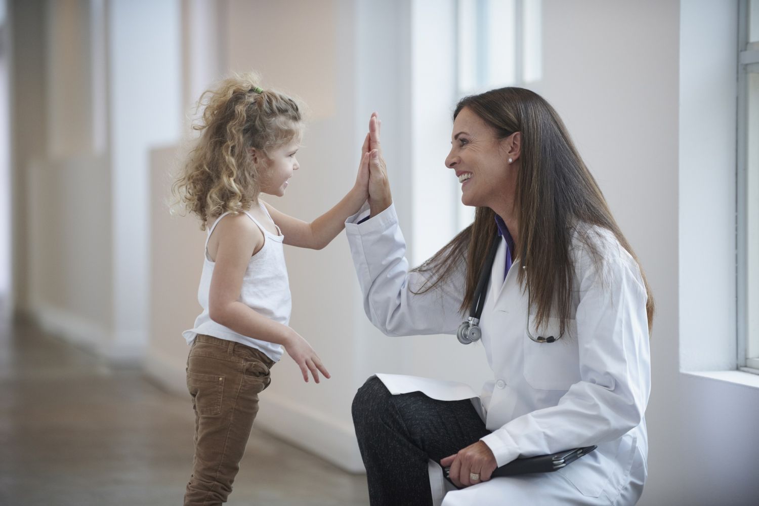 Ärztin und kleines Mädchen geben sich High 5